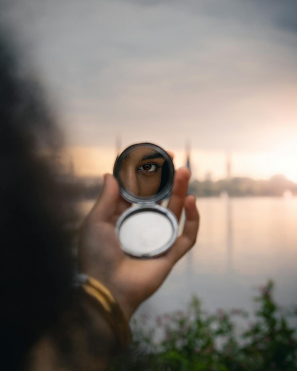 a person holding a mirror in front of their face